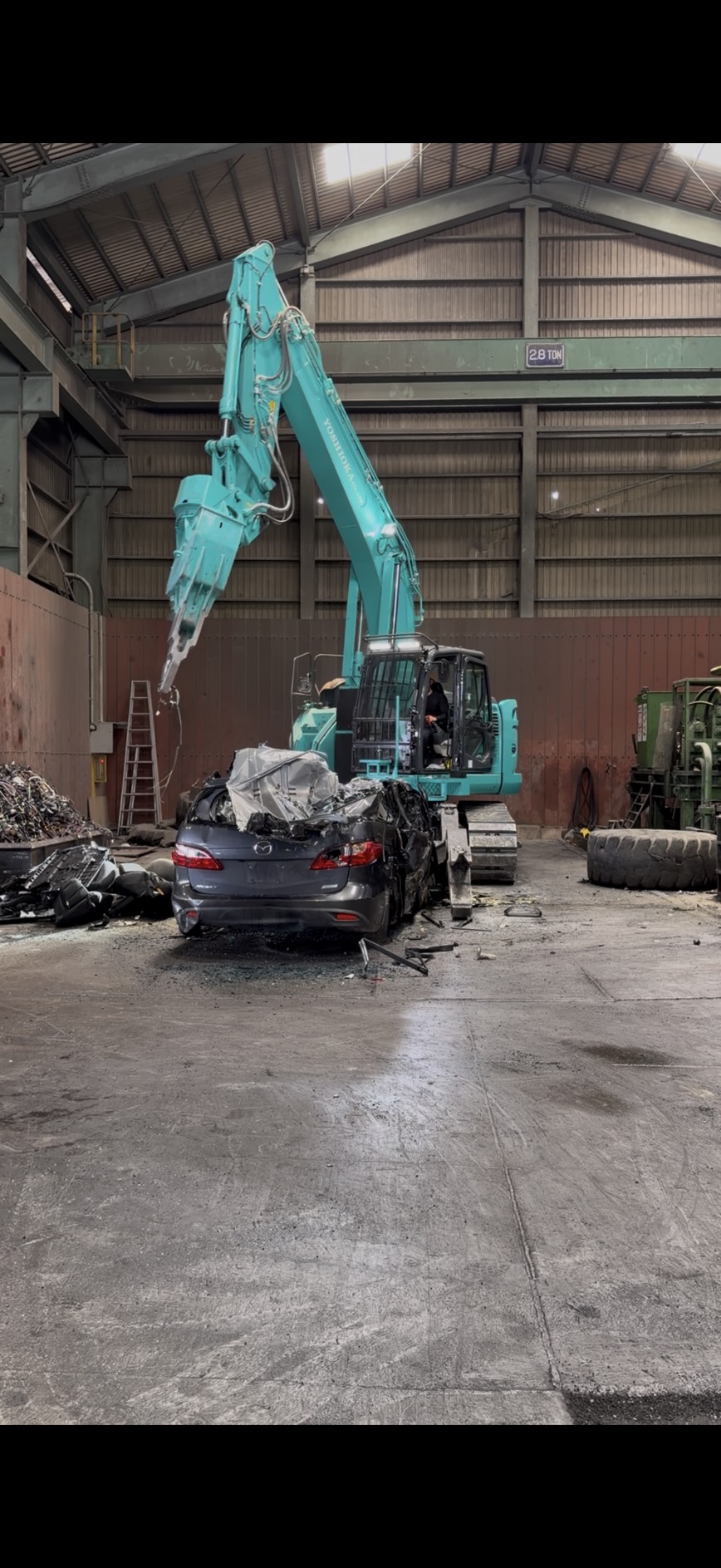 自社工場で重機を使って車両を解体する様子
